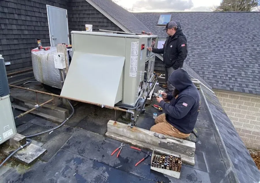 HVAC technician working on rooftop equipment