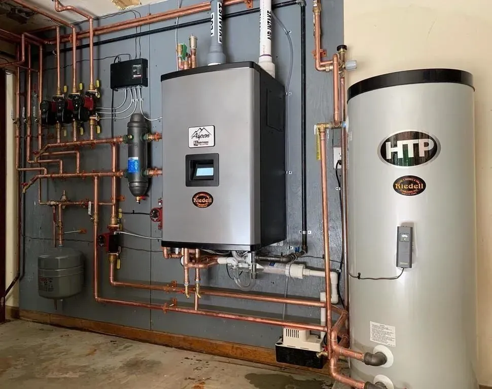 Wall-mounted boiler connected to an indirect water heater with neat copper piping
